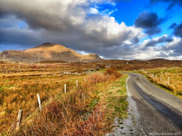 Driving along the Wild Atlantic Way in the Connemara region. Here the mountain peaks are many and the valleys are deep. This coastal road hugs craggy cliffs and sandy shores, and it never gets old.