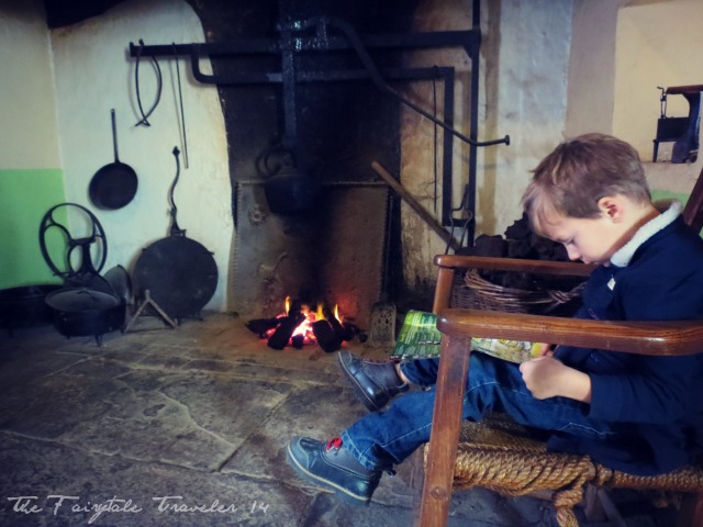 The "Little" reading a map by the fire at the Bunratty Heritage Park at Bunratty castle.